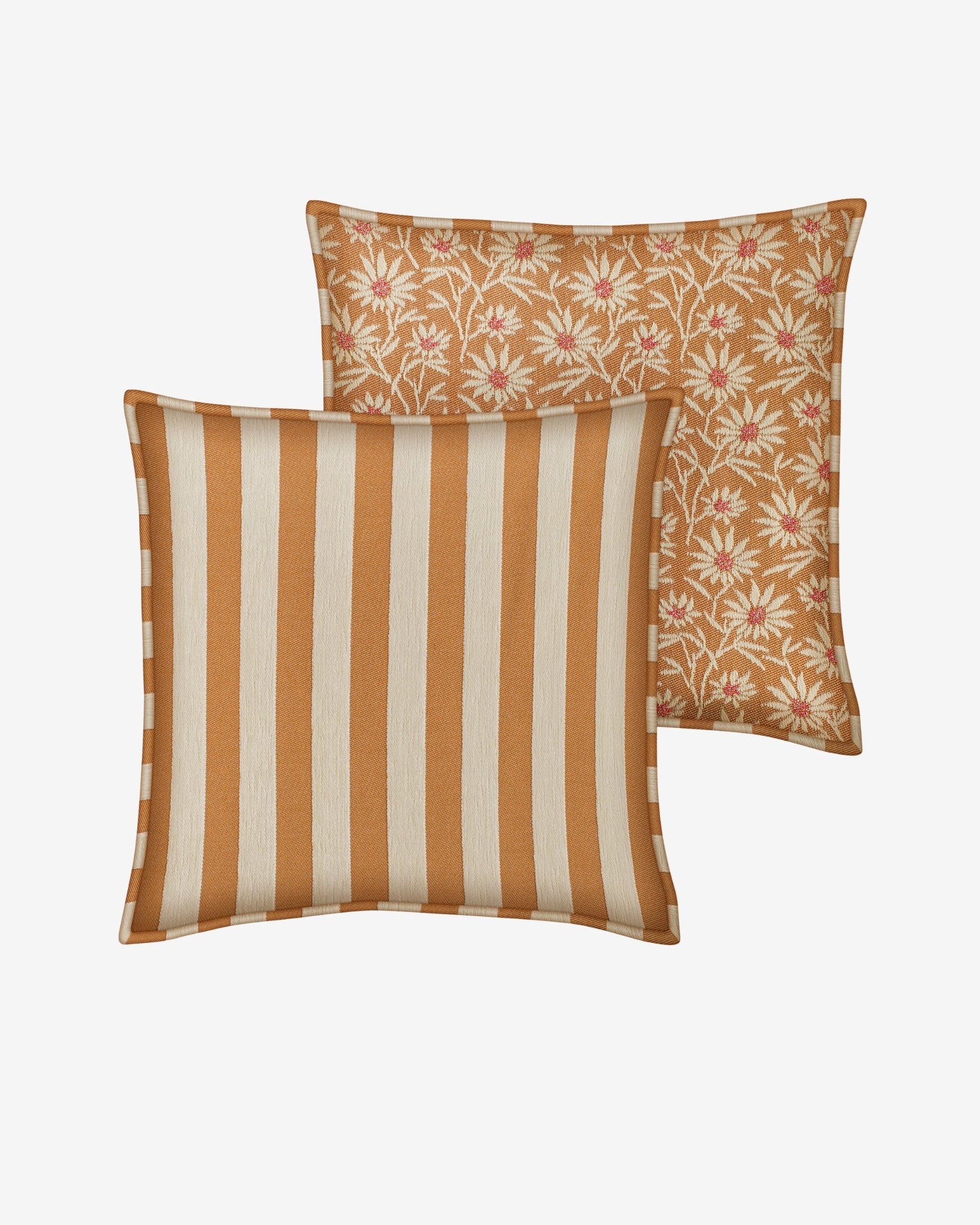Two decorative throw pillows on a light gray background. The front pillow features vertical stripes in warm rust orange and cream, while the back pillow shows a matching rust orange background with a pink and cream floral pattern.
