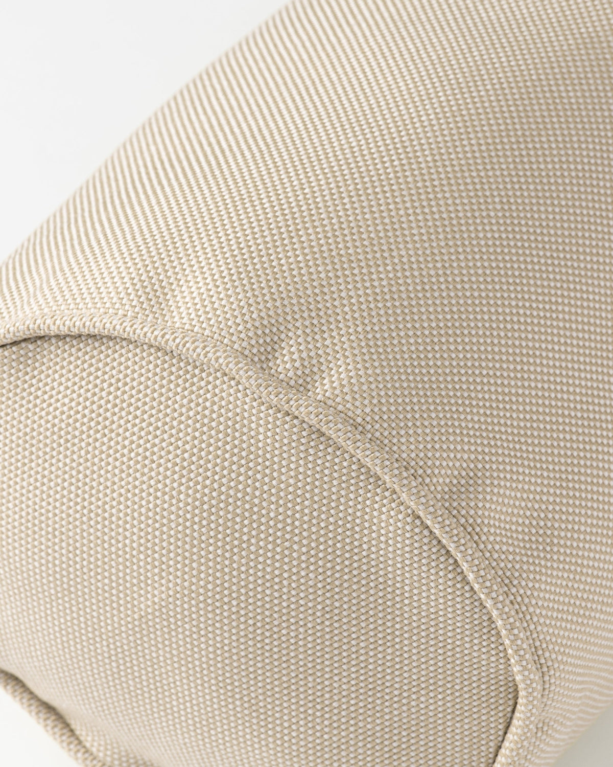 Close-up of a beige woven fabric product, showing the texture and curved seam against a plain light background.